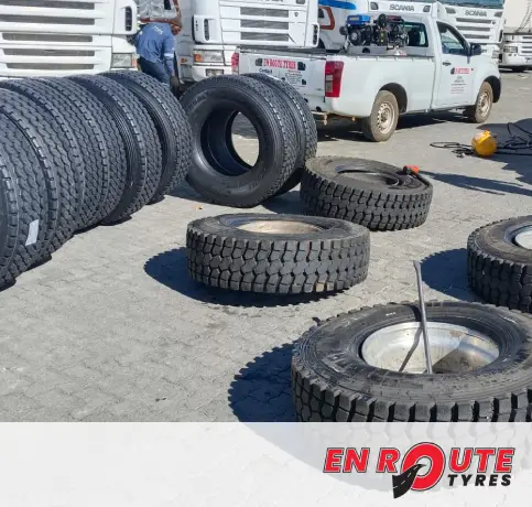 A stack of new and retread tyres for a truck and passenger vehicles at the EN ROUTE TYRES workshop.